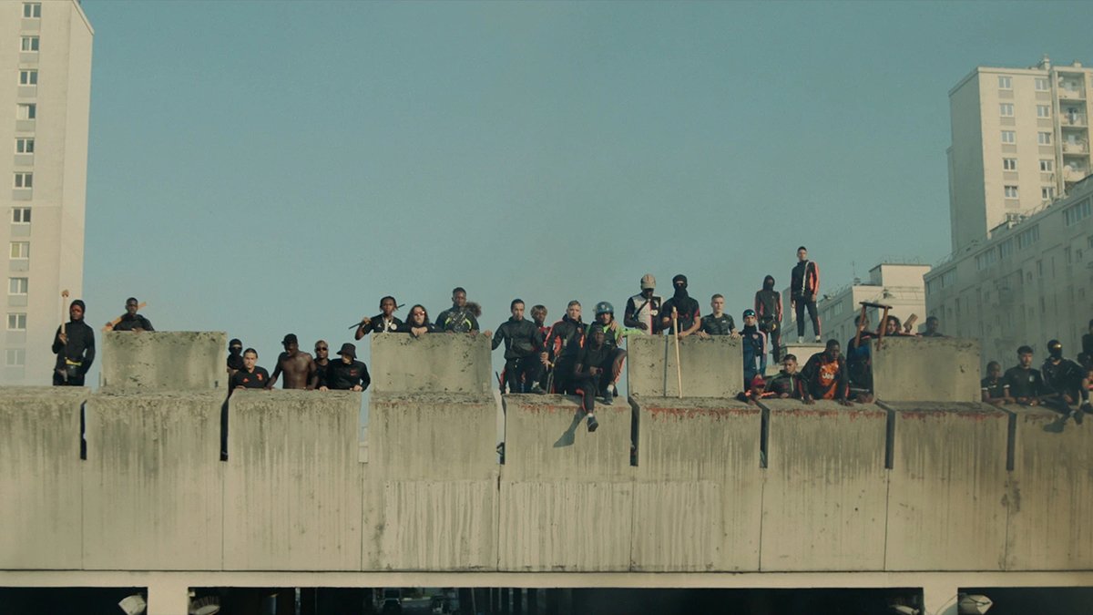 A cena de Athena mostra manifestantes em cima de uma ponte com fumaça.